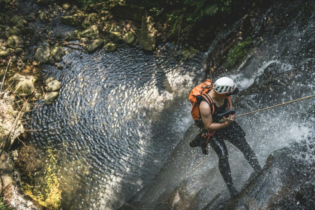 a man in a helmet is rapping a waterfall