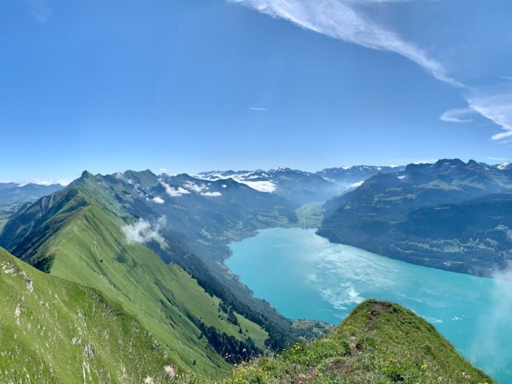 green mountains near lake under blue sky during daytime